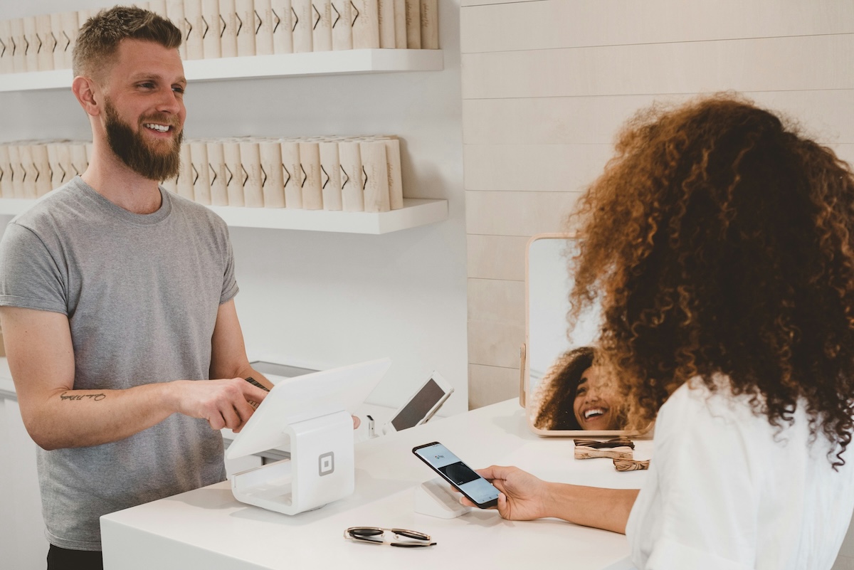 Small business owner using AI SEO tools on laptop with growth charts showing improved search rankings - AI SEO for small business